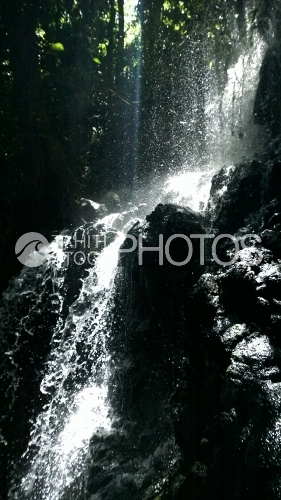 Tahiti, waterfall in the forest, under the sunlight