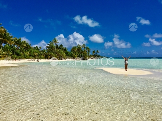 Beautiful young lady on a sand bank in the lagoon of Tetiaroa
