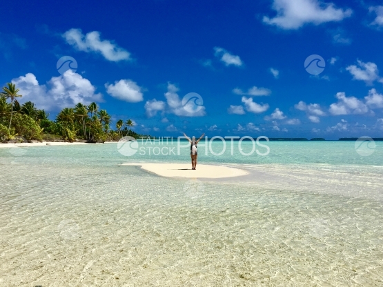 Beautiful young lady on a sand bank in the lagoon of Tetiaroa