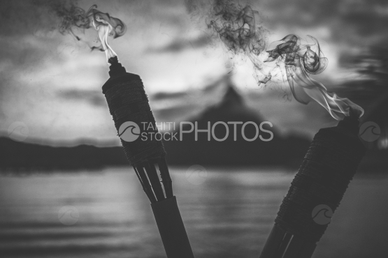 Flame of a torch on the beach, lagoon of Bora Bora in the background