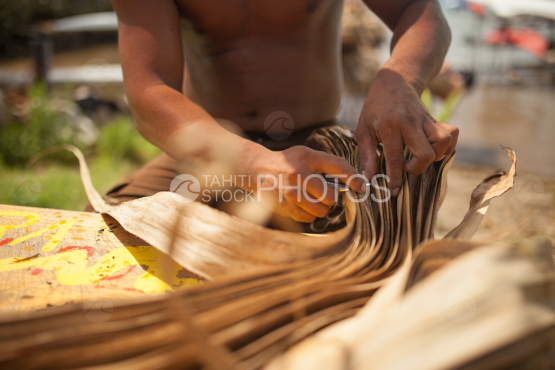 Polynesian working on leaves of pandanus