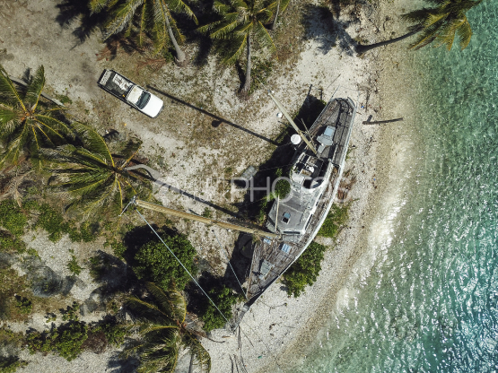 Rangiroa, aerial shot of a wreck of sail boat laid on the island