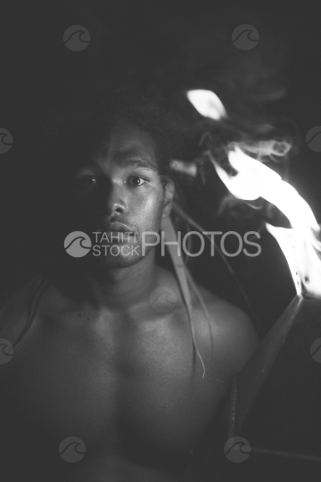 BORA BORA, PORTRAIT OF POLYNESIAN MAN WITH FIRE TORCH AT NIGHT