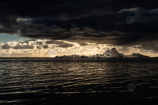 Island of Bora Bora under a stormy sky at sunset time