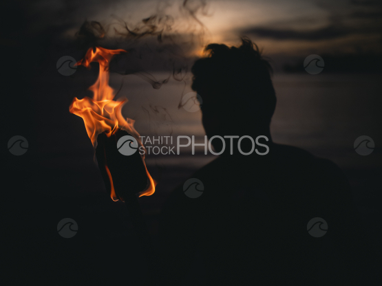 BORA BORA, PORTRAIT OF POLYNESIAN MEN WITH FIRE TORCH AT NIGHT by the lagoon