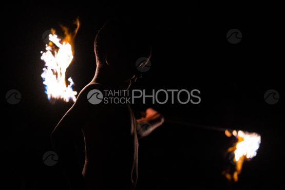 BORA BORA, PORTRAIT OF POLYNESIAN boy WITH FIRE TORCH AT NIGHT